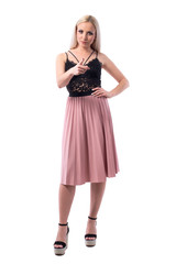 Angry young stylish blonde woman looking at camera and pointing finger blaming you. Full body isolated on white background.