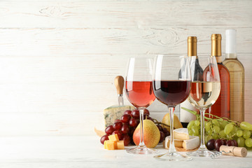 Fruits, cheese, bottles and glasses with different wine on white background, space for text