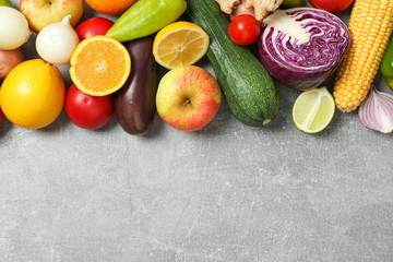 Different vegetables and fruits on grey background, copy space