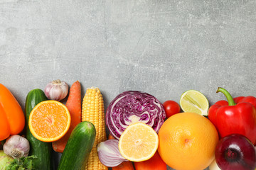 Different vegetables and fruits on grey background, copy space