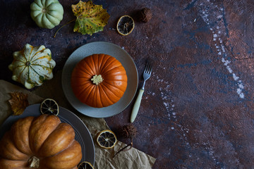 Pumpkin on a plate. Autumn cozy background with leaves, vanilla.