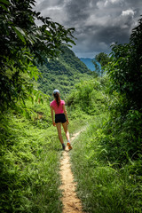 Obraz premium Young woman trekking at the mountains of Pu Luong, North Vietnam. Pu Luong is a beautiful rural area with karst mountains, forests and rice fields. 