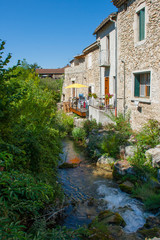 A small river running through a French village in the Drome region