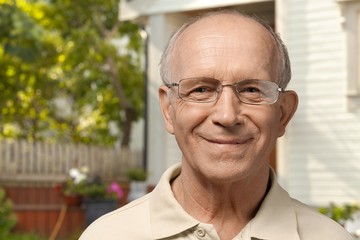 Handsome senior man standing on the house background
