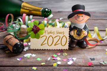Chalkboard with four leaf clover and chimney sweeper and sparklers with happy new year 2020 on...