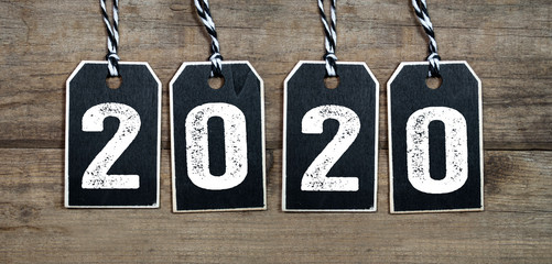 Chalkboard with four leaf clover and chimney sweeper and sparklers with happy new year 2020 on...