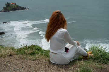 Red haird girl in long white skirt  traveler in nature looking to beautiful view and small island in Vung Tau.Relax time on holiday concept travel .