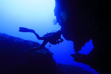 Fototapeta na wymiar 宮古島市下地島にあるダイビングスポットの海底洞窟の女王の部屋で泳ぐダイバー