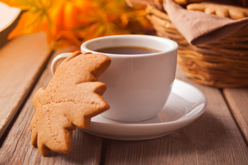 Cup of coffee, autumn leaves, cookies on the wooden table. Autumn harvest. Autumn concept.