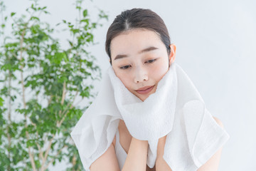 タオルで顔をふく女性