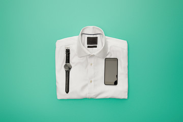 top view of watches and smartphone on plain white folded shirt on turquoise background