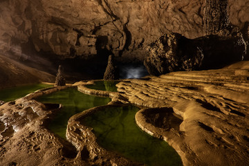 Nguom Ngao cave in North Vietnam, Cao Bang province. Enormous stalagmites and reflecting water pools. Vietnamese landscape. 