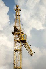 Fototapeta na wymiar yellow automobile crane with risen telescopic boom outdoors over blue sky