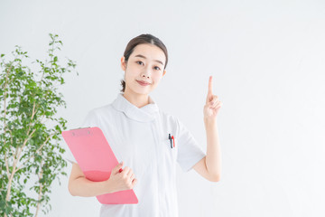 指で「1」をつくる白衣の女性