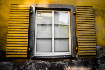 Closed window with yellow shutters