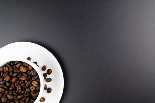 cup of coffee and coffee beans on dark background