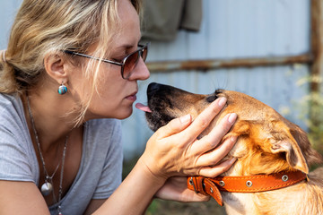 A woman caresses her dog for a walk. Face to face.