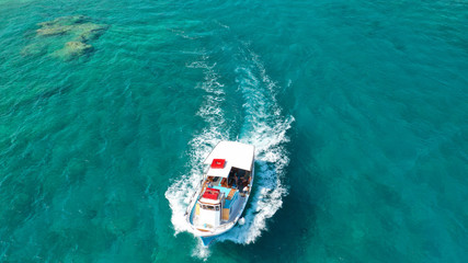 Aerial drone photo of picturesque and traditional tourist vessel cruising in famous beaches of Koufonisi island, Small Cyclades, Greece