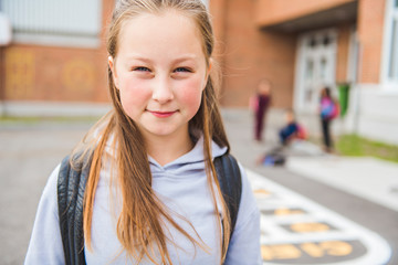 Fototapeta premium A student school girl on the playground on the first day of class