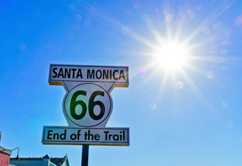 Road sign of route 66 as the terminus on Santa Monica beach on a sunny day.