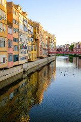 Fototapeta na wymiar Colourful facade building landmark reflected on river water in Girona, Catalonia