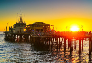 View of Santa Monica Pier on the beach at sunset.