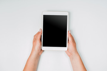 Modern workspace with woman hands and tablet pc copy space on white color background. Top view. Flat lay style. Minimalism