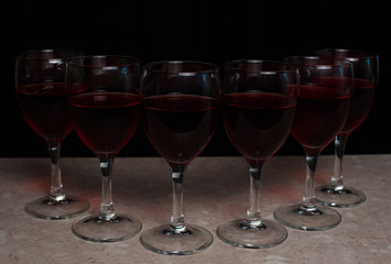 Six red wine glassen on black backgound