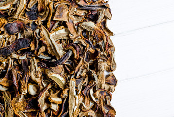 many dried mushrooms lies on a white wood desk