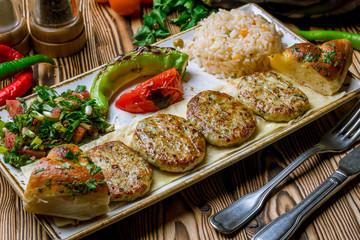 Cutlets with vegetables in Turkish cuisine on wooden table