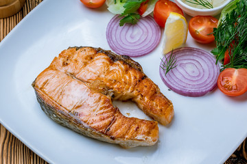 Salmon steak on the grill on wooden table