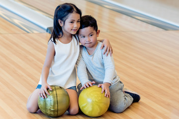 Fototapeta premium Portrait images of Asian sisters and brothers sat on the bowling alley, to childrens and sports concept.
