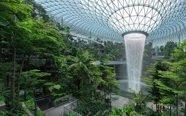  Jewel Changi Airport is a new terminal building under a glass dome, with indoor waterfall and tropical forest, shopping malls and dining, in Singapore - obrazy, fototapety, plakaty