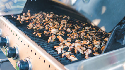 Sliced pickled mushrooms, grilled, picnic with barbecue in the open air. Mushrooms barbecue roasted on metal grill. Diet vegan bbq.