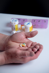 rugged working hands of a man holding  pain medication prescription bottle on white. shallow depth of field