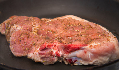 Fresh raw pork steak with spices roasting on frying pan