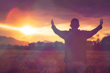 soft focus and Silhouettes of man raise hand up worship God  against blurred sunset sky . Christian background with copy space for your text - obrazy, fototapety, plakaty
