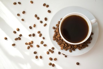 cup of coffee with beans on white background
