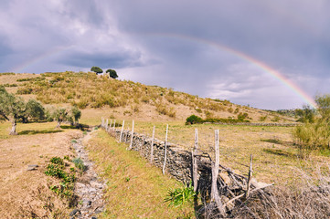 Paisaje tormentoso con doble arcoíris