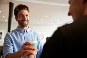 Male Barista Serving Customer With Takeaway Coffee