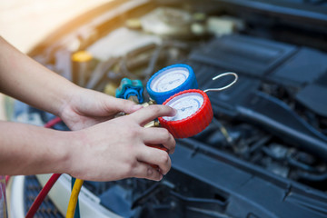 Auto mechanic Worker hands holding and point to monitor to check and fixed car air conditioner system in car garage