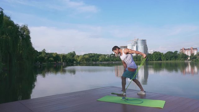 Athletic man in sport clothing doing exercise with expander