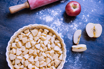 Traditional homemade apple pie and ingredients on wooden background for autumn holiday