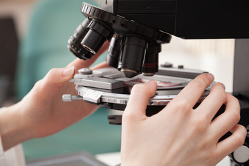 Fototapeta na wymiar Laboratory assistant uses a polarizing microscope in a microbiological laboratory