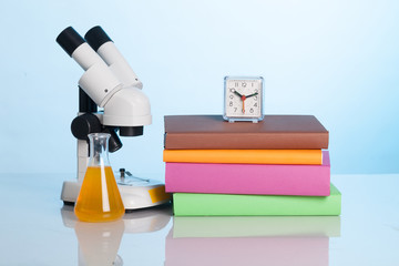 Books and a microscope on the desk of the student