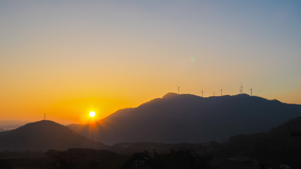 Obraz premium sunrise in the morning with mountain,fog and windmild in south korea during Autumn.