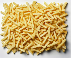 Large Pile of cooked Crinkle Chips/fries against white