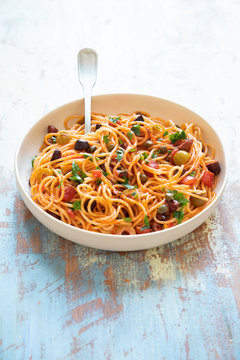 Traditional Itallian pasta spaghetti alla puttanesca with anchovies, tomatoes, olives, capers, garlic and parsley.