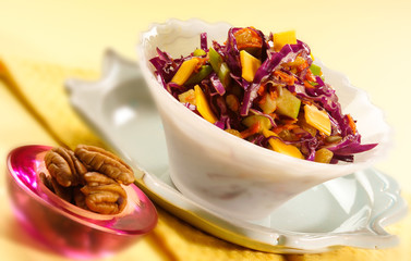 Waldorf style Salad in white bowl with extra walnuts on the side