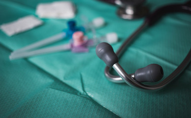 Stethoskop vor Kanülen Spritzen auf sterilem Tisch